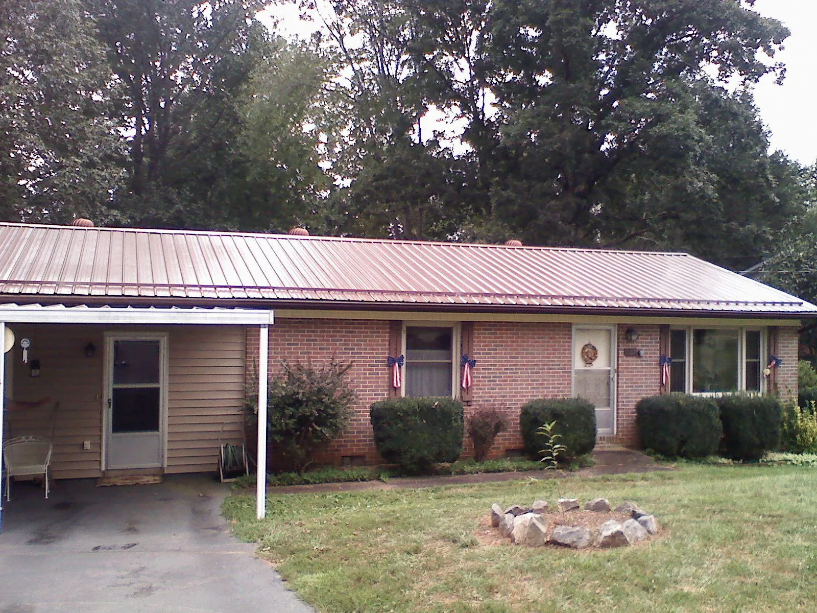 Bronze metal roof and carport on a brick ranch home — Roof Repair work by our crew in Alpine